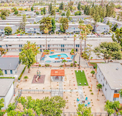 A large white building with a pool in the middle of a grassy area.