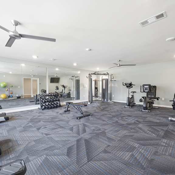 A spacious gym with treadmills, elliptical machines, and other exercise equipment.