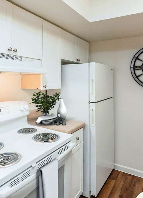A small kitchen with a white stove and a white refrigerator.