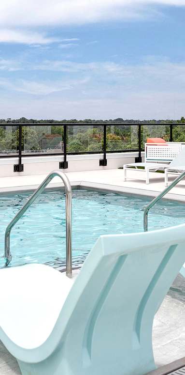 A pool with a white and blue lounge chair.