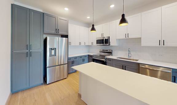 A kitchen with a refrigerator, microwave, and oven.
