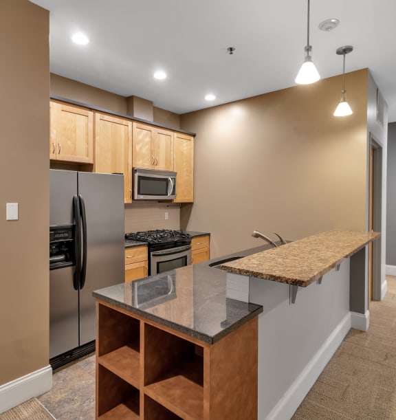 a kitchen with stainless steel appliances and a counter top at The Granite Works Apartments , Buffalo, NY, 14202