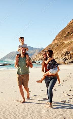 A family of three is walking on a beach.