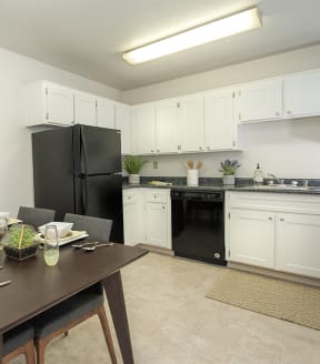 River Pointe apartments model unit kitchen with black appliances and white cabinets 