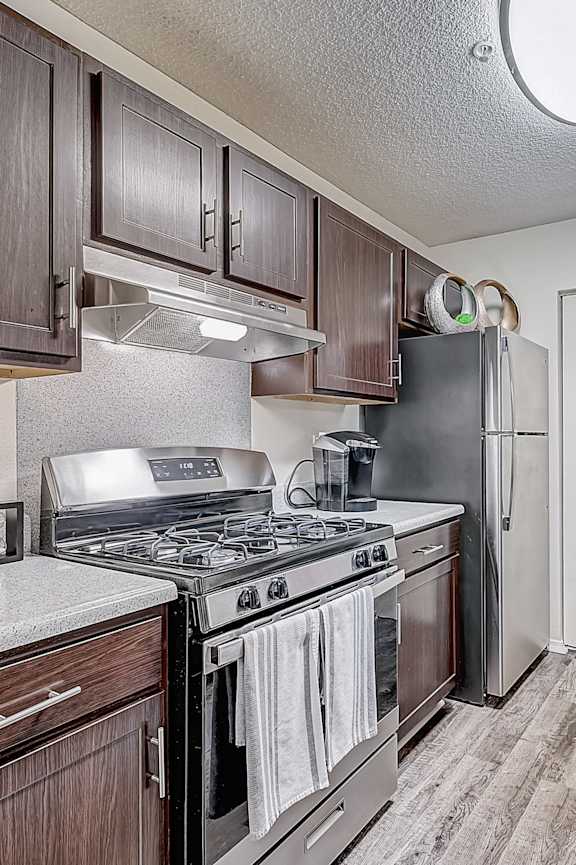 A kitchen with a stove top oven and a refrigerator.
