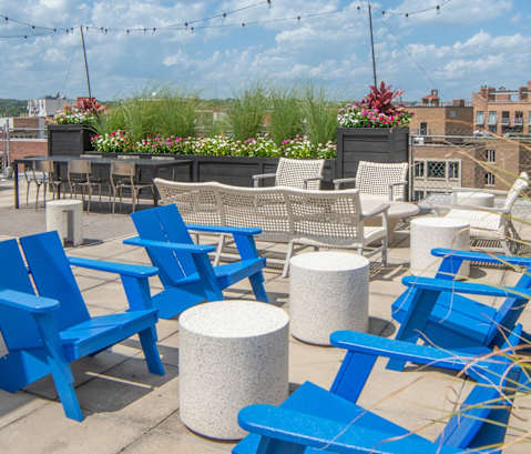 an outdoor patio with blue chairs and tables on a sunny day