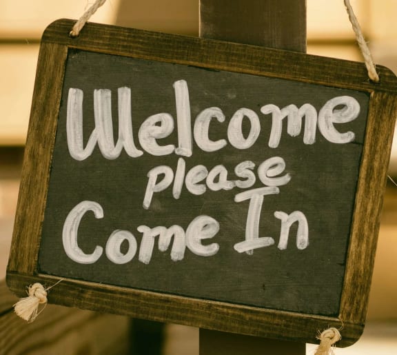 a sign that reads welcome please come in