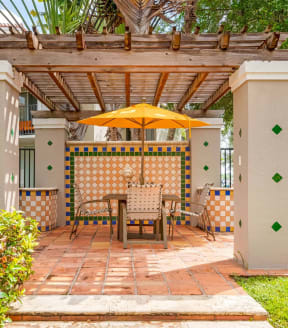 a pergola with a table and chairs under it