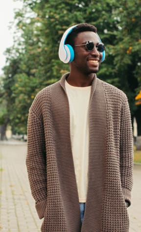 a man wearing headphones walking down the street