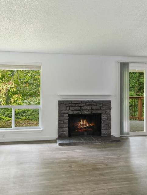 A room with a fireplace and sliding glass doors.