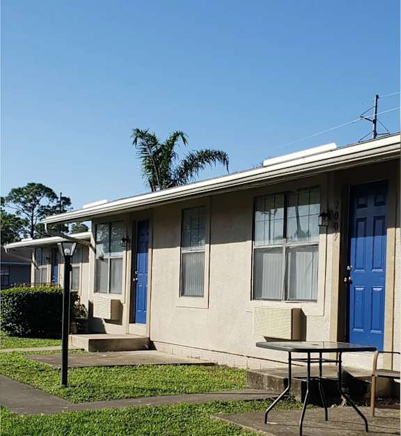 a house with a blue door and a table in front of it