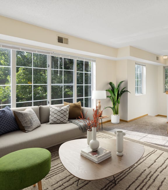 a living room with a table and chairs and a kitchen in the background