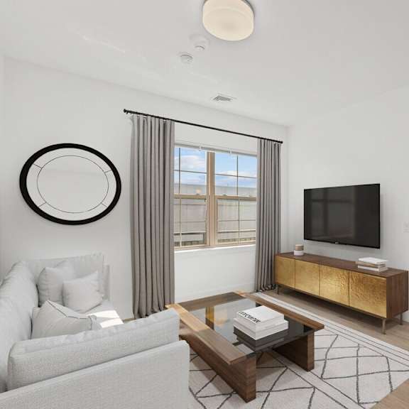 A modern living room with a grey couch, a wooden coffee table, and a flat-screen TV.
