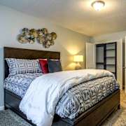 A bedroom with a large bed and a wall decoration.