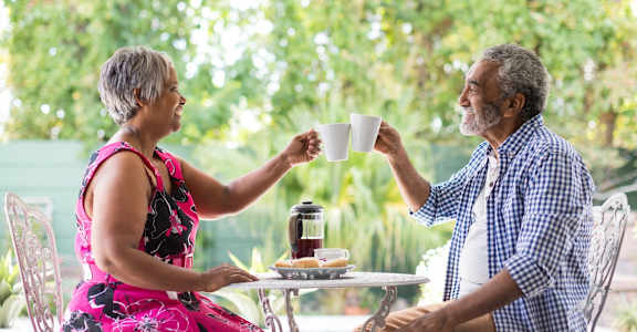 a man and a woman sitting at a table with a cup of coffee
