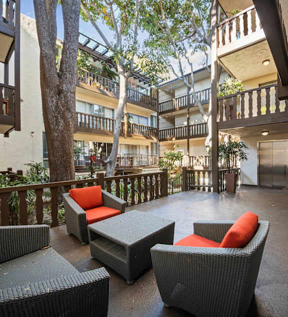 a living room with a blue couch and a patio door  at Mediterranean Village West Hollywood, West Hollywood