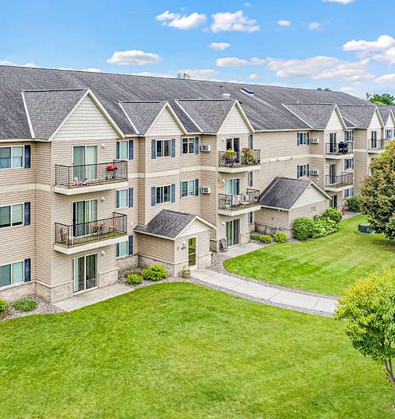 A large apartment complex with a green lawn in front.