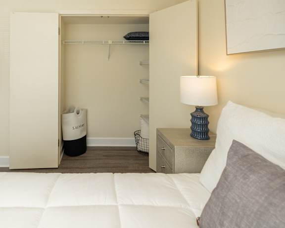 A bedroom with a white bed and a painting on the wall at The Brittany Apartments, Maryland