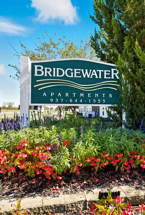 A sign for Bridgewater Apartments is surrounded by flowers.