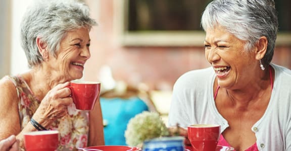 Elderly women sharing a hot beverage