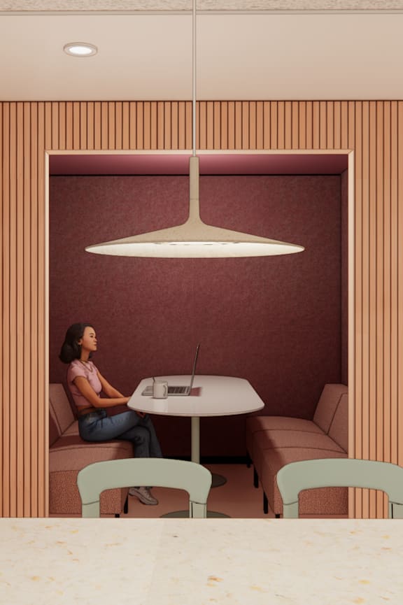 Three people are sitting at a table in a room with a brick wall.