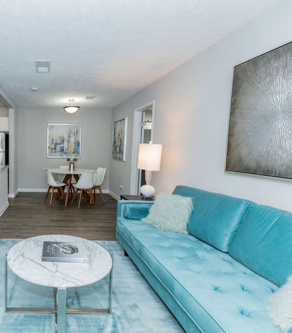 a living room with a blue couch and a table  at The Atlantic Howell Station, Duluth, GA