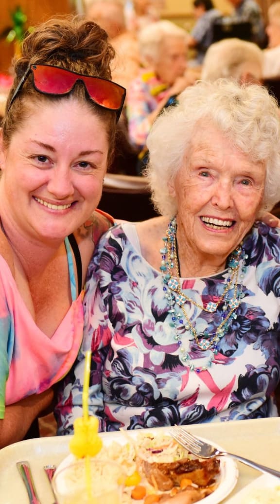 two elderly women sitting at a table with a bottle of wineat River Commons Senior Living, Redding