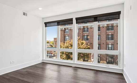 A room with a large window and wooden flooring.