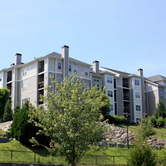 an apartment building on a hill with trees