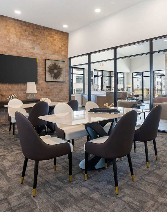 A conference room with a brick wall and a long table with chairs.