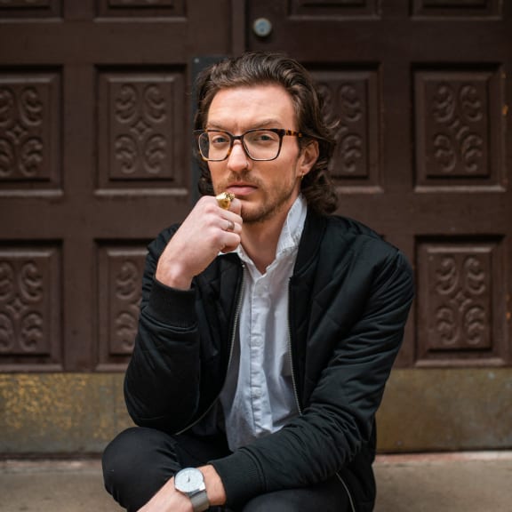 a man sitting on the ground smoking a cigarette