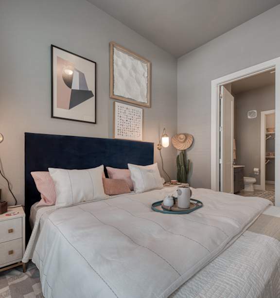 A bedroom with a large bed and a hat on a bedside table.