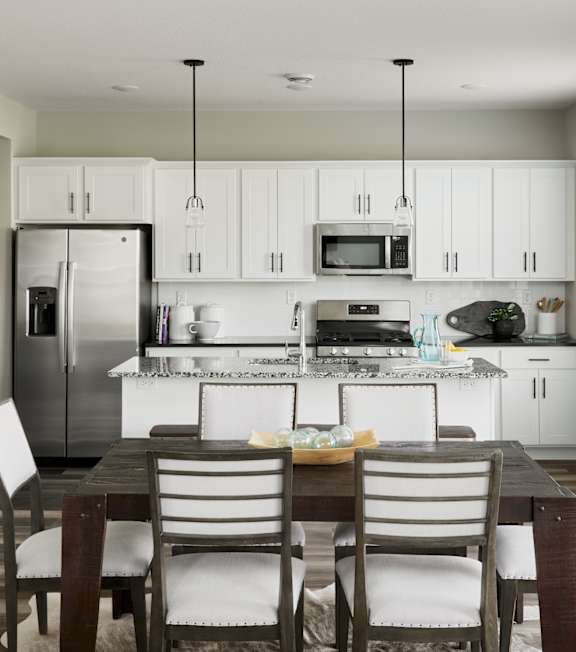 A modern kitchen with a dining table and chairs.