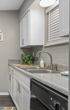 a kitchen with white cabinets and black appliances