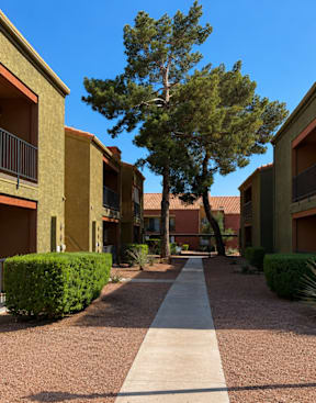A long concrete walkway separates apartment buildings.