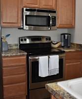 A kitchen with brown cabinets and a stainless steel refrigerator.