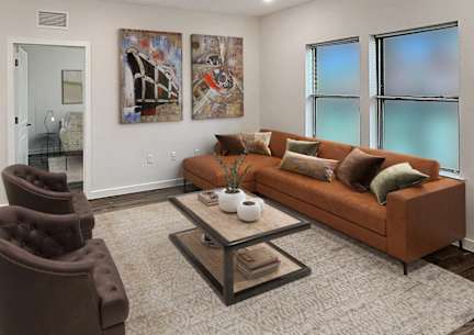 A living room with a brown couch, a coffee table, and a painting on the wall.