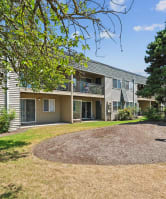 the roundabout in front of an apartment building with grass and trees