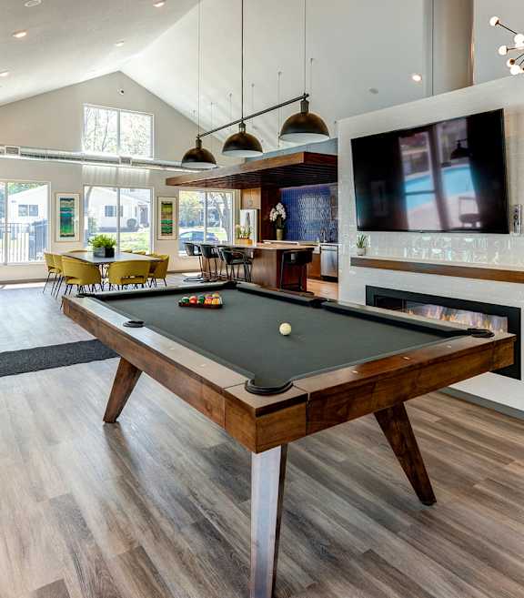 A room with a pool table and a television.
