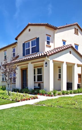 a row of houses on the side of a green lawn at The Vines at Riverpark, LLC, Oxnard California