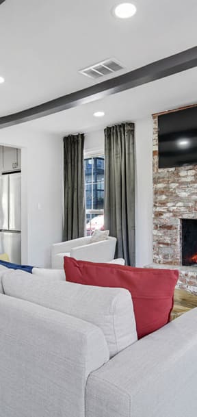 Shared area with a fireplace and grey sofa