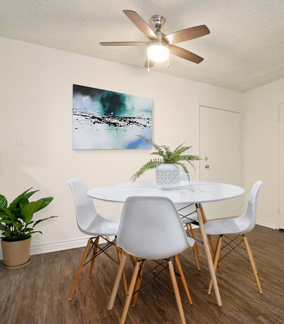 A dining room with a white table and chairs.