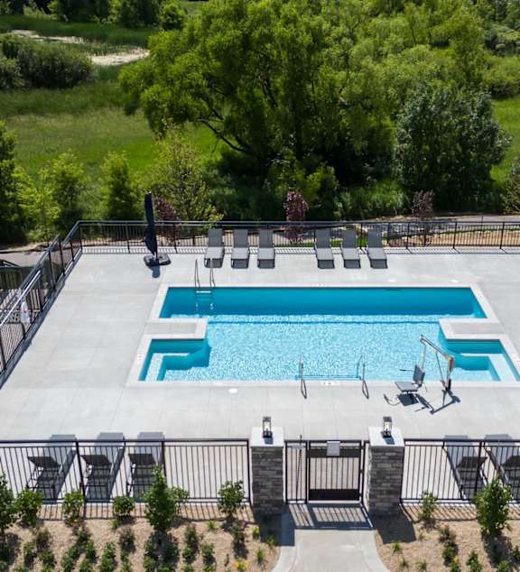 A large outdoor swimming pool surrounded by a fence.