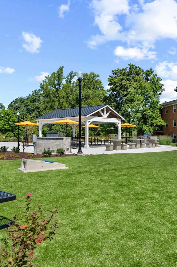 a park with picnic tables and a gazebo in front of a building at Courthouse Square Apartments, Maryland