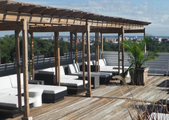 a roof deck with lounge chairs and a pergola
