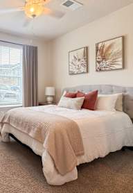 A bedroom with a large bed and a ceiling fan.