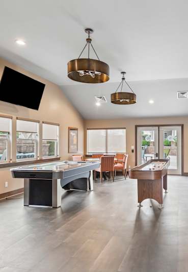 A spacious room with a pool table and a television.