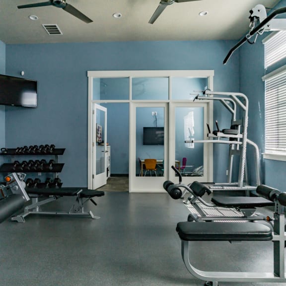 a home gym with exercise equipment and a television