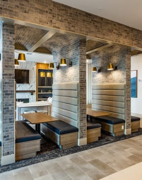 a seating area in a hotel lobby with benches and a tv