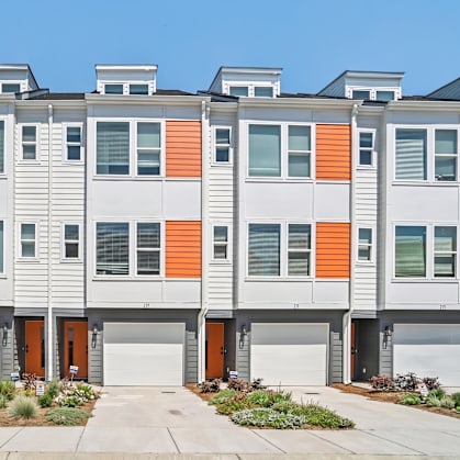 A modern apartment building with orange and grey accents.
